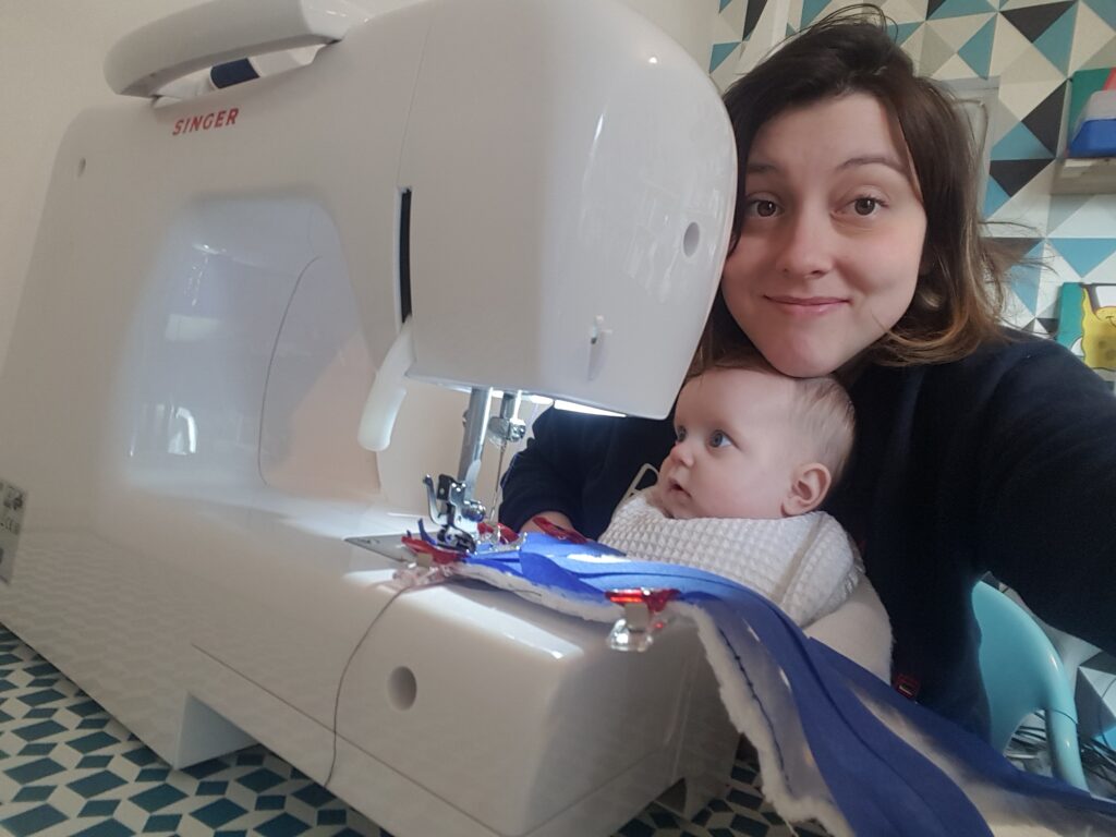 photo justine avec un bébé sur les genoux devant une machine à coudre