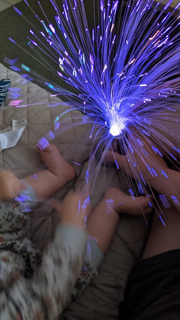 Photo d'enfants jouant avec une lampe munie de fibre optique.