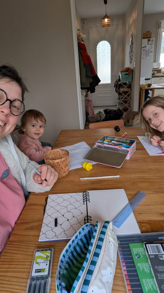 Photo d'une maman qui dessine avec ses enfants.